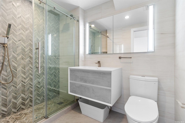 bathroom with toilet, tile walls, vanity, and walk in shower