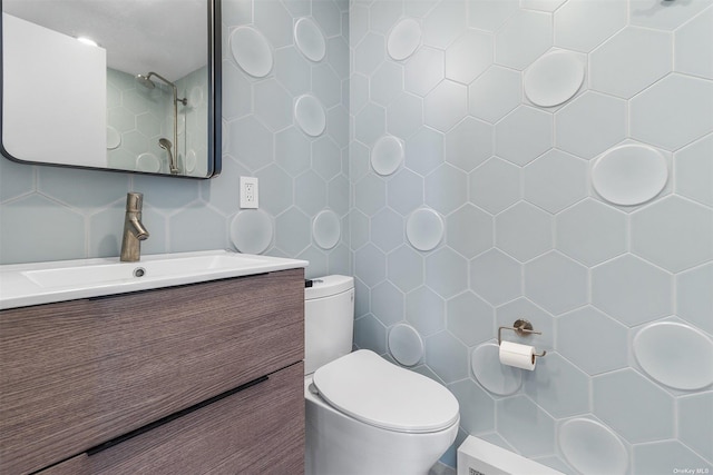 bathroom with vanity, tile walls, and toilet