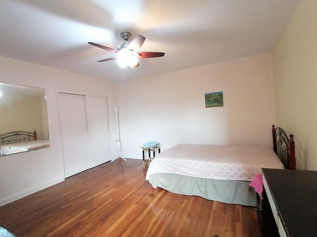 bedroom with ceiling fan, dark hardwood / wood-style flooring, and a closet