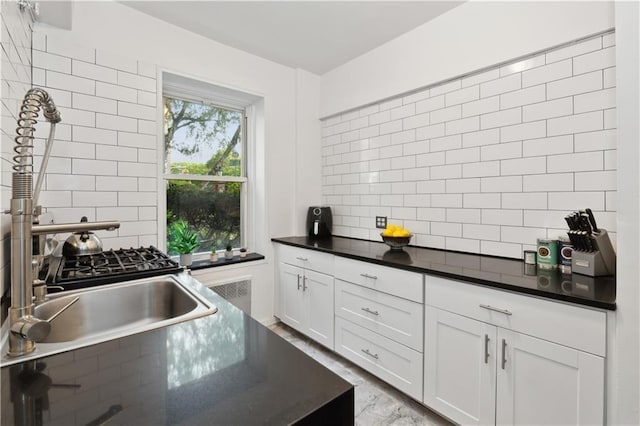 kitchen with white cabinetry, sink, and decorative backsplash