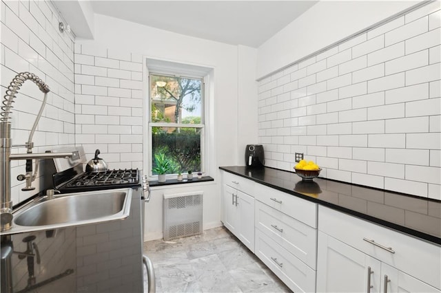 kitchen with white cabinetry, sink, and tasteful backsplash