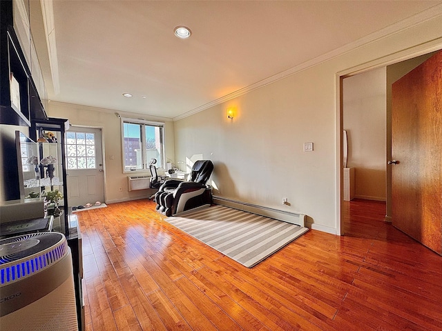 exercise room featuring ornamental molding, a baseboard heating unit, and hardwood / wood-style floors