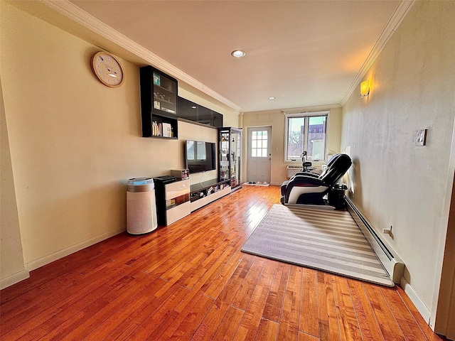 interior space featuring a baseboard heating unit, hardwood / wood-style flooring, and crown molding