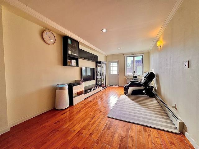 exercise area with crown molding, a baseboard radiator, and hardwood / wood-style floors