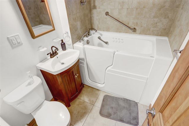 full bath featuring toilet, a tub, vanity, and tile patterned floors