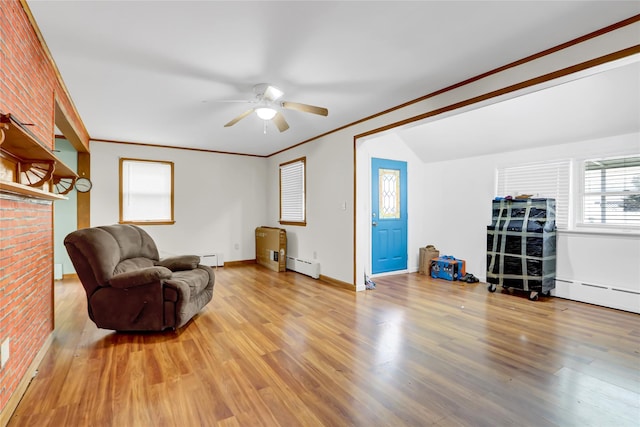 sitting room with a baseboard radiator, a baseboard heating unit, baseboards, light wood-style floors, and ornamental molding