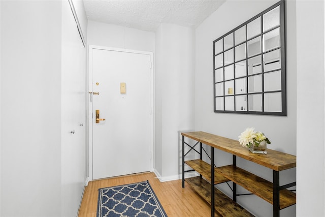 doorway with hardwood / wood-style flooring and a textured ceiling