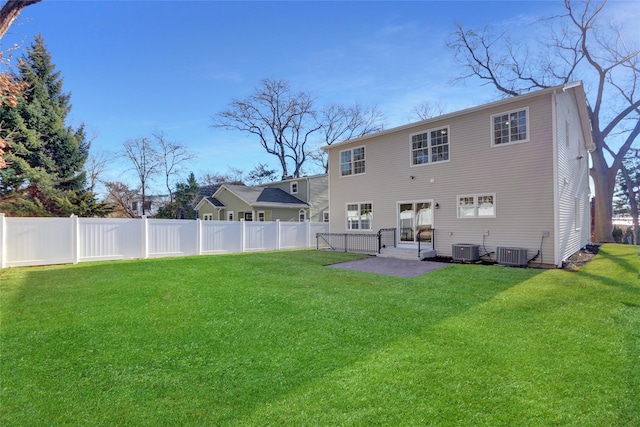 rear view of house featuring a yard, central AC unit, and a patio area