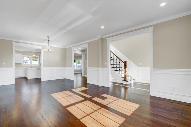 unfurnished living room with crown molding, dark hardwood / wood-style floors, sink, and a notable chandelier