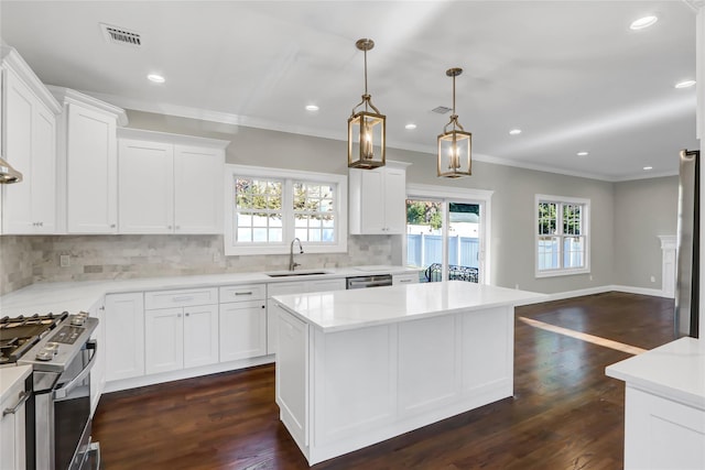 kitchen featuring hanging light fixtures, appliances with stainless steel finishes, a center island, and white cabinets