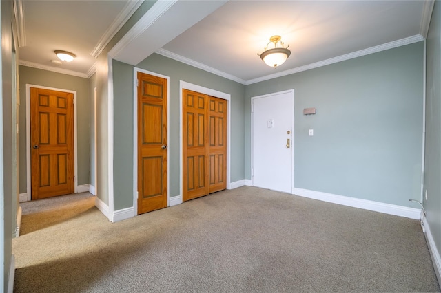 carpeted entrance foyer featuring ornamental molding