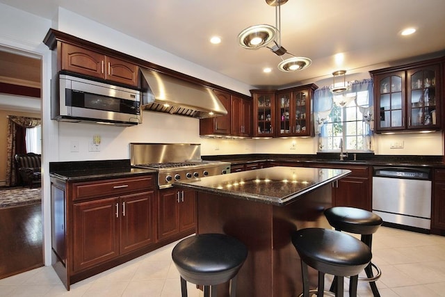 kitchen featuring extractor fan, a kitchen island, sink, hanging light fixtures, and stainless steel appliances