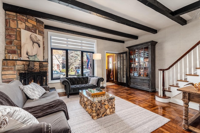 living room with beamed ceiling, a fireplace, and dark parquet floors