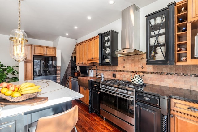 kitchen featuring sink, appliances with stainless steel finishes, backsplash, exhaust hood, and dark stone counters