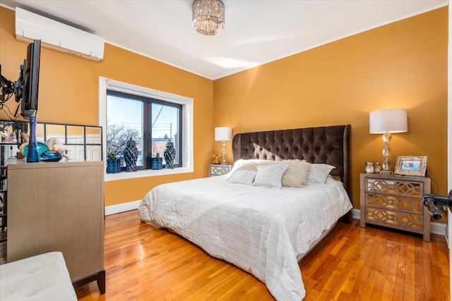 bedroom with hardwood / wood-style flooring and an AC wall unit