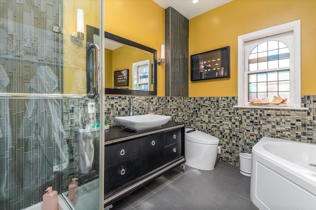 full bathroom featuring independent shower and bath, vanity, tile walls, and tile patterned floors