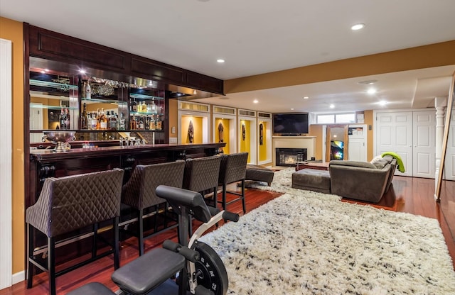 bar featuring dark hardwood / wood-style flooring and light stone countertops