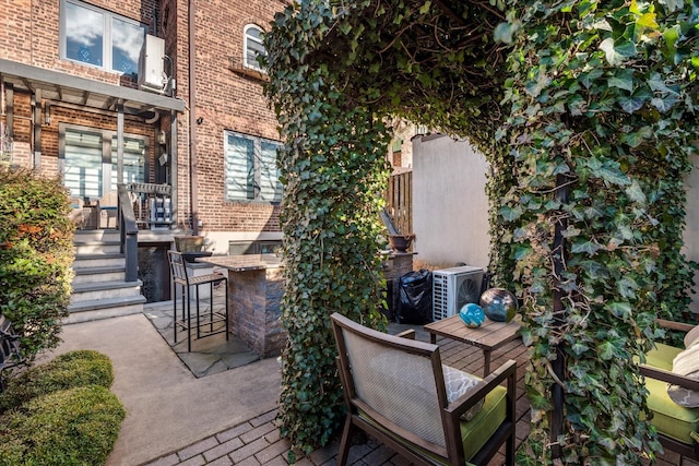 view of patio featuring ac unit and a bar