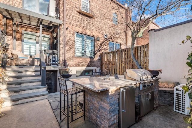 view of patio / terrace featuring a bar, area for grilling, and a grill