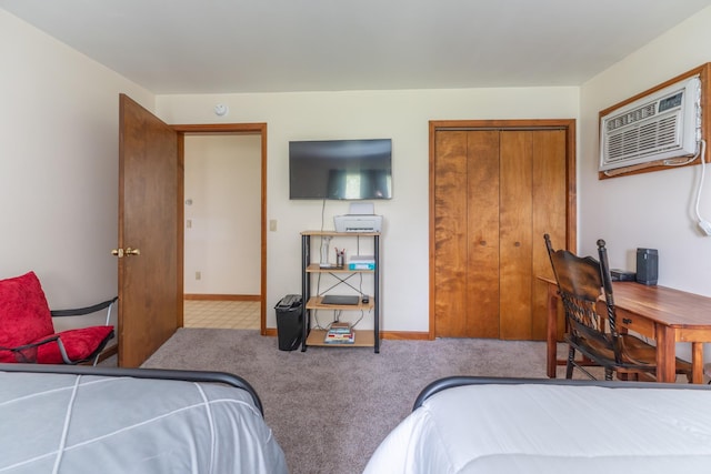 carpeted bedroom with an AC wall unit and a closet