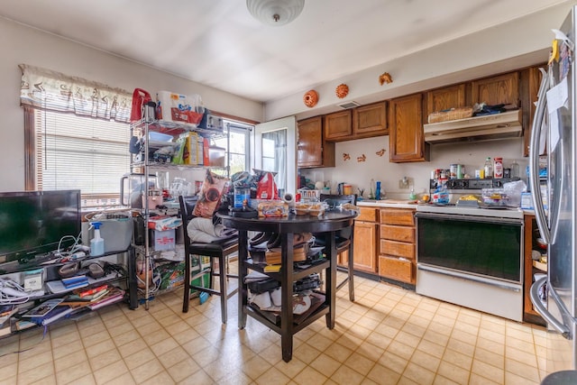 kitchen with stainless steel fridge and white range with electric stovetop