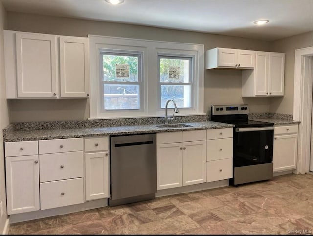 kitchen featuring dark stone countertops, sink, stainless steel appliances, and white cabinets