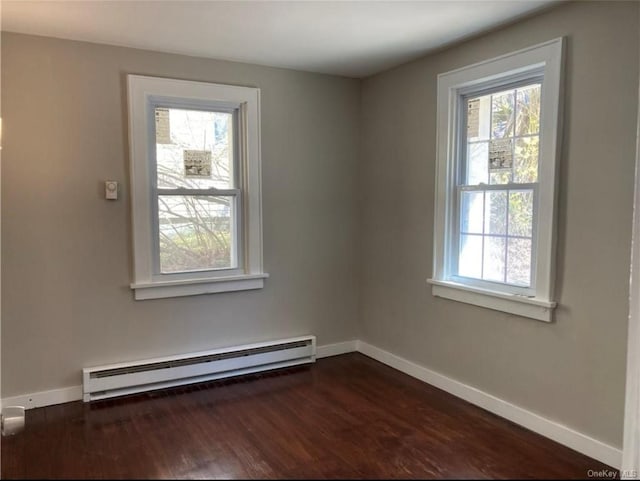 empty room with a baseboard radiator, a healthy amount of sunlight, and dark hardwood / wood-style floors