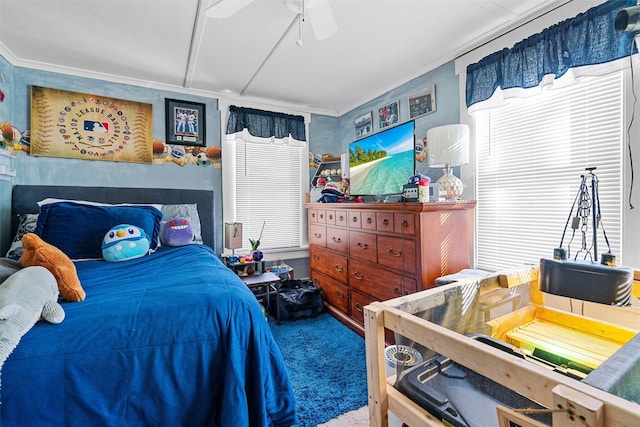 carpeted bedroom with ceiling fan and ornamental molding