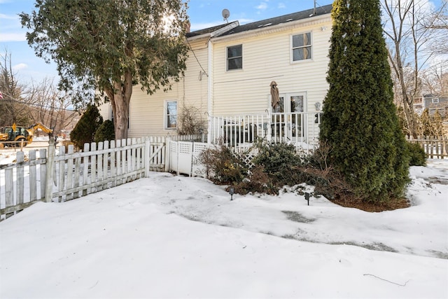 view of snow covered rear of property