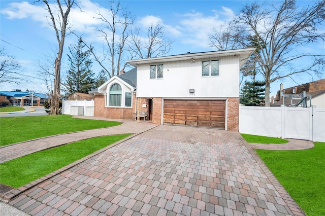 view of front of house featuring a garage, brick siding, fence, decorative driveway, and a front yard