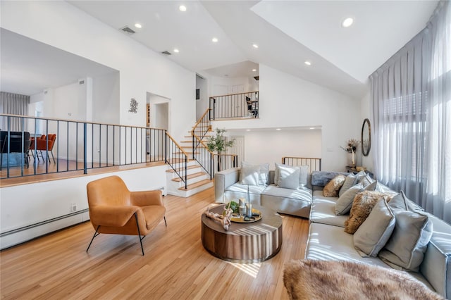 living area with high vaulted ceiling, recessed lighting, visible vents, light wood-style floors, and stairs