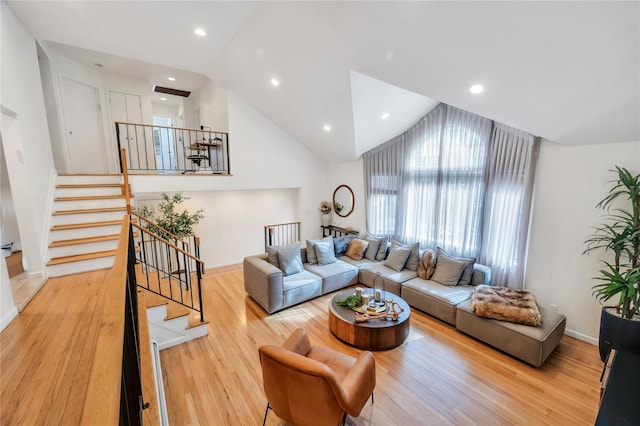 living area with light wood finished floors, baseboards, stairway, and recessed lighting