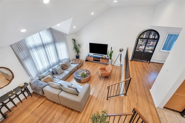 living area featuring light wood-style flooring, high vaulted ceiling, and recessed lighting