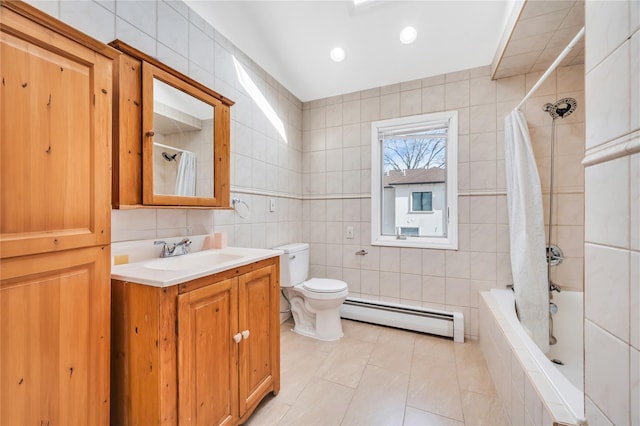 full bathroom with toilet, a baseboard radiator, tiled shower / bath combo, vanity, and tile walls