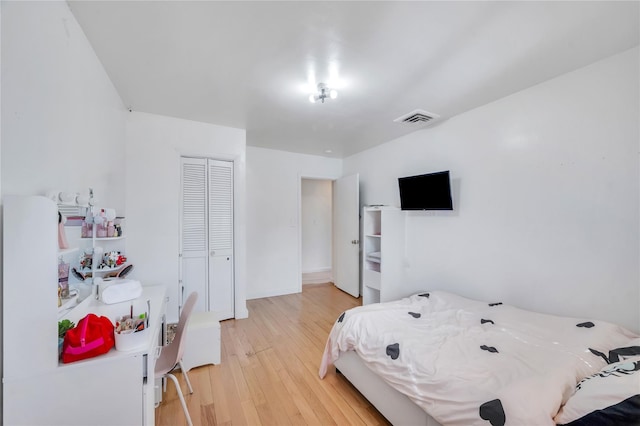 bedroom featuring a closet, visible vents, and light wood-style flooring