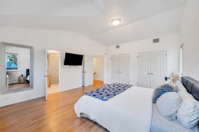 bedroom with lofted ceiling, light wood-type flooring, visible vents, and multiple closets