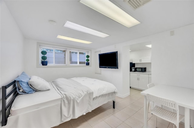 bedroom featuring light tile patterned floors, visible vents, and baseboards