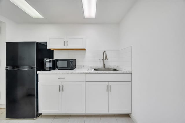 kitchen featuring black appliances, tasteful backsplash, white cabinetry, and a sink