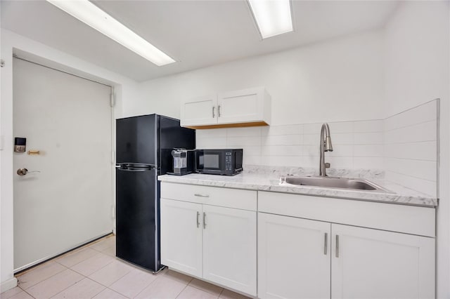 kitchen featuring black appliances, backsplash, a sink, and white cabinets