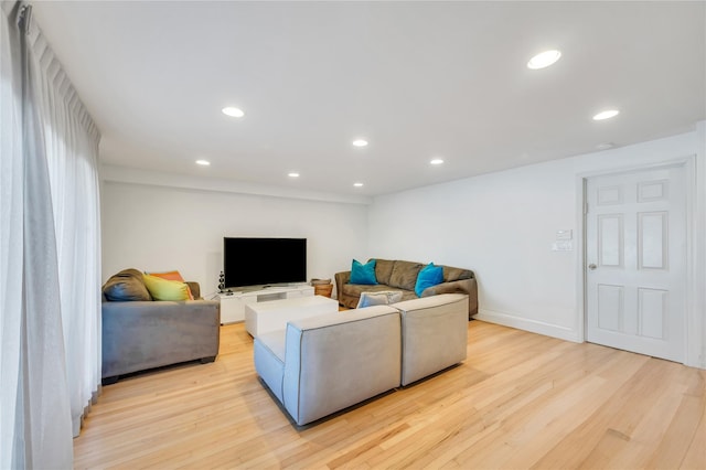 living room with light wood-style floors, baseboards, and recessed lighting