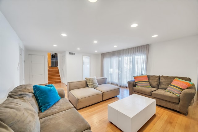 living area featuring stairs, recessed lighting, visible vents, and light wood-style floors