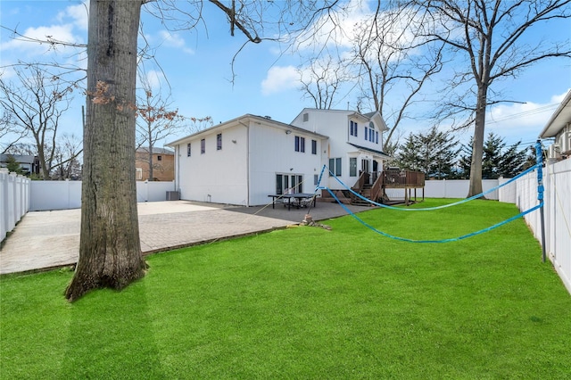 back of house featuring a patio area, a fenced backyard, and a lawn