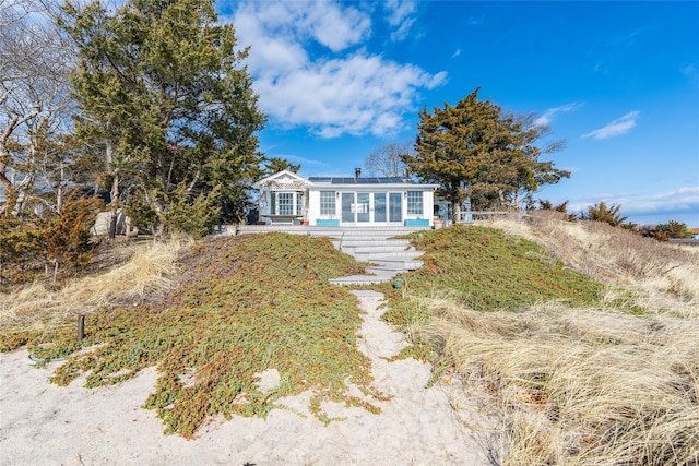 view of front of house with solar panels and a sunroom