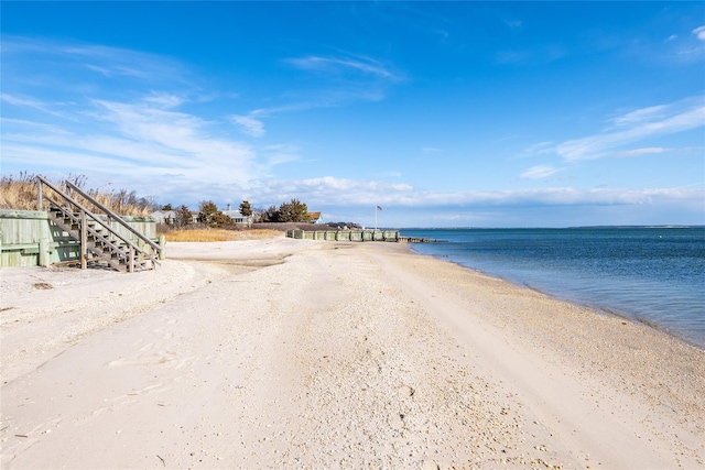 property view of water with stairway and a beach view