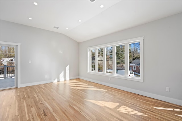 unfurnished room featuring light hardwood / wood-style floors and vaulted ceiling