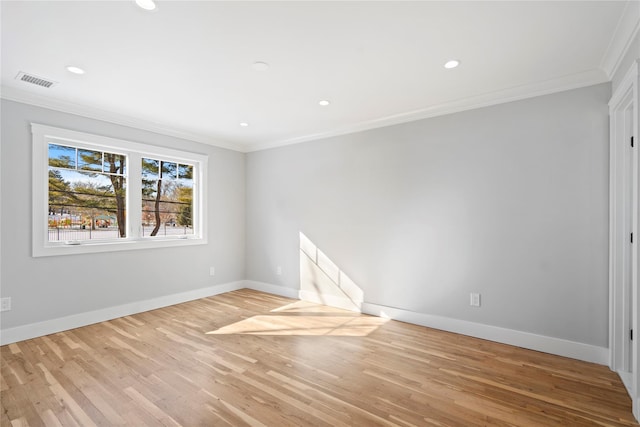 spare room with ornamental molding and light wood-type flooring