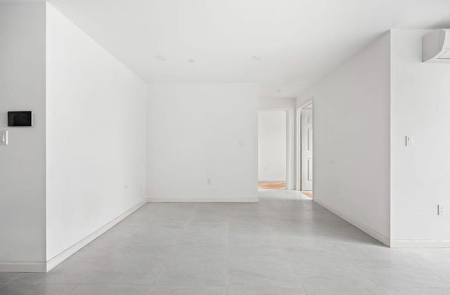 unfurnished room featuring an AC wall unit