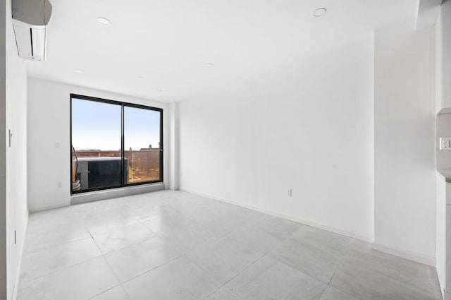 unfurnished room featuring a wall unit AC