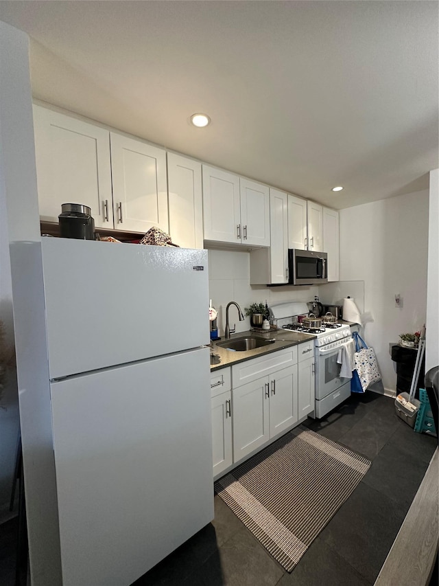 kitchen with sink, white appliances, and white cabinets