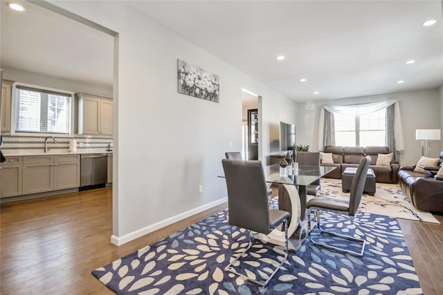 living area with recessed lighting, plenty of natural light, wood finished floors, and baseboards